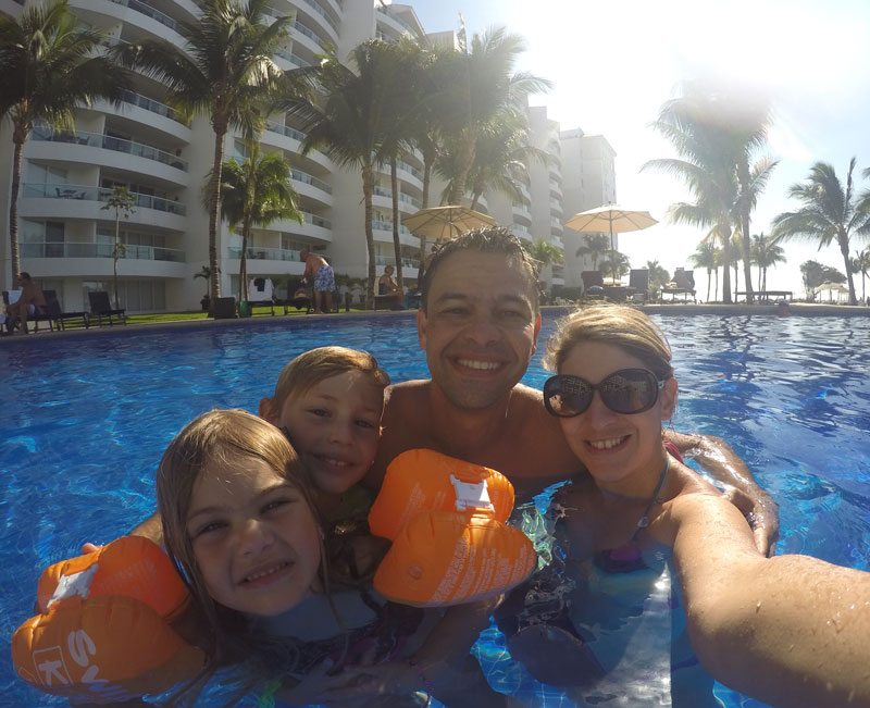 Farmacinha com remédios para viagem: família na piscina do resort